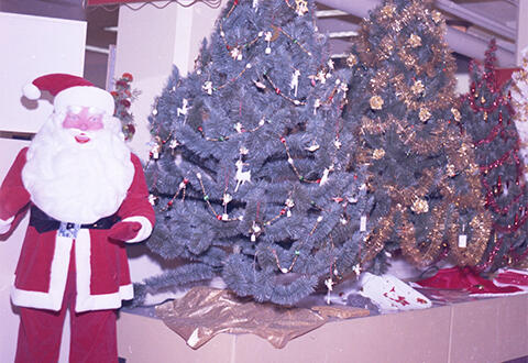 Santa Claus character posed with Christmas Tree